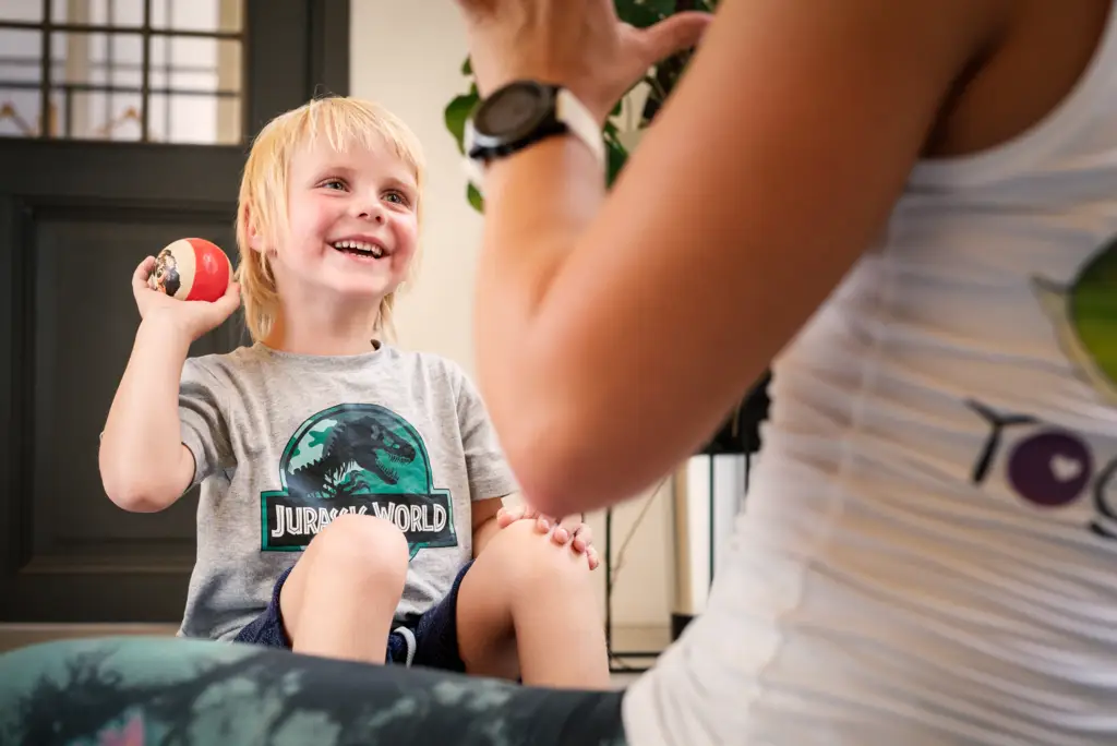 Ein Kind wirft einen Ball zu Monika