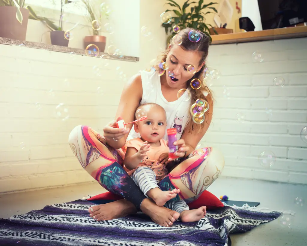 Monika bläst Seifenblasen mit einem Baby